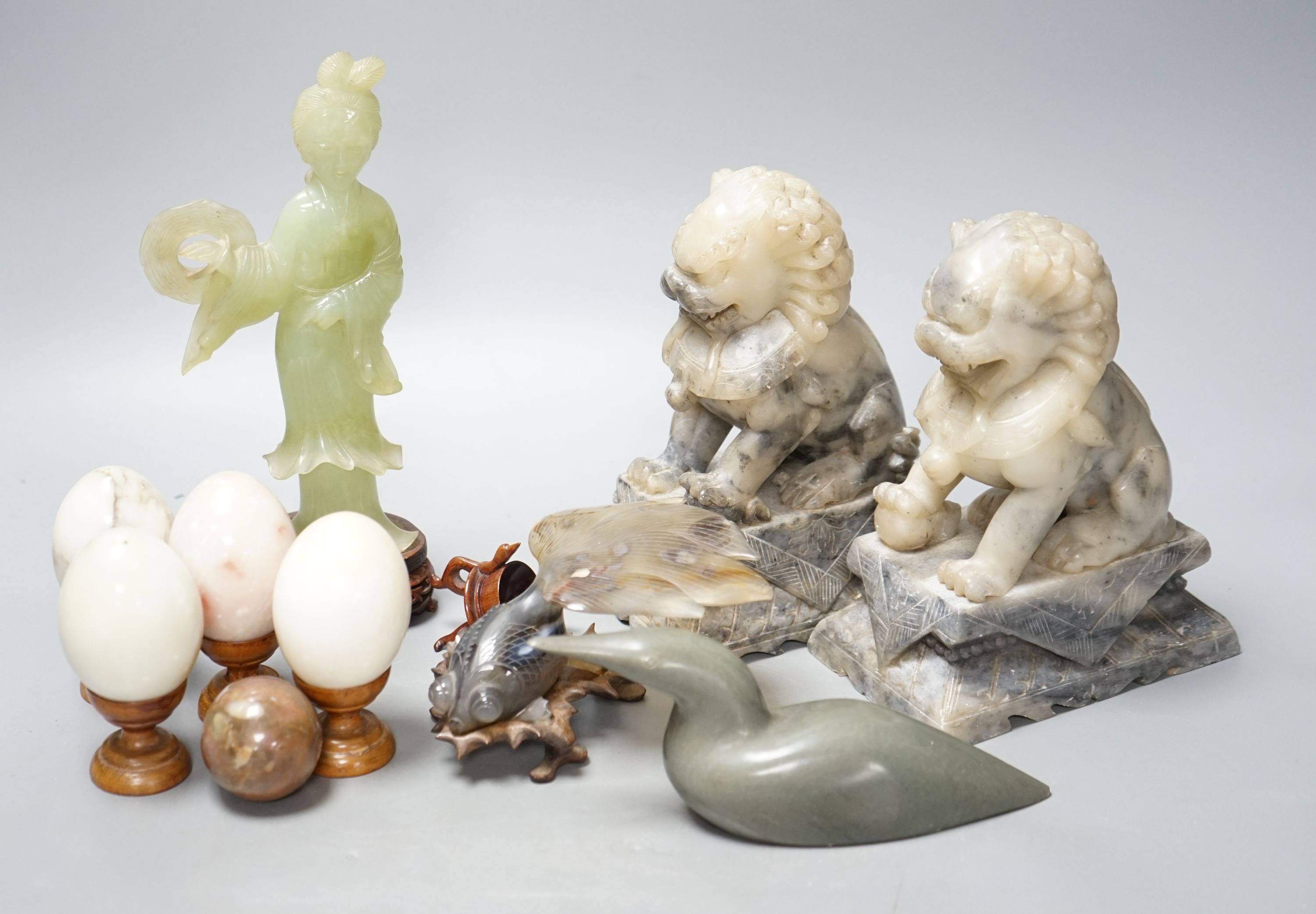 A pair of Chinese soapstone stone carvings of Buddhist lions, 18cm, two Chinese hardstone carvings, an Inuit carving and five hardstone eggs